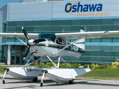 plane with pontoons in front of hanger